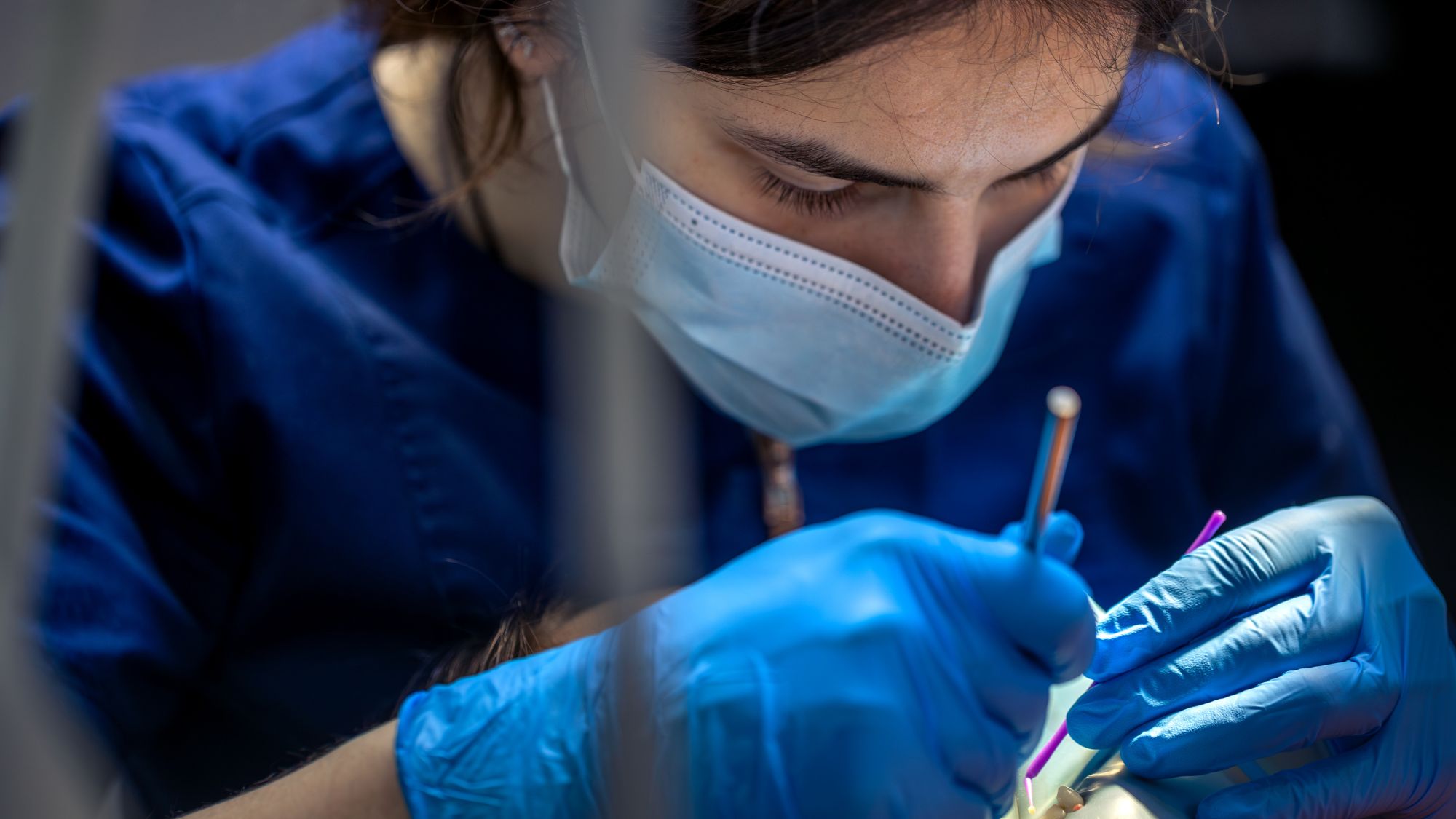 A dentist for bleeding gums is working on a patient