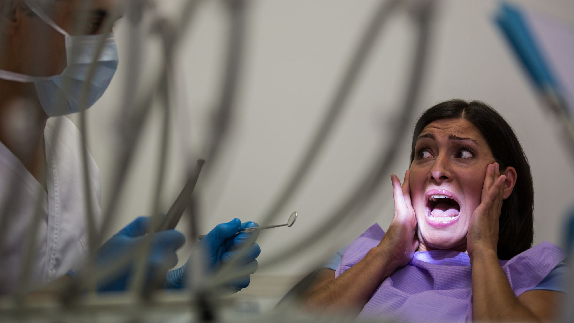 A woman feeling anxious in a modern dental office, experiencing dental anxiety during a dental visit