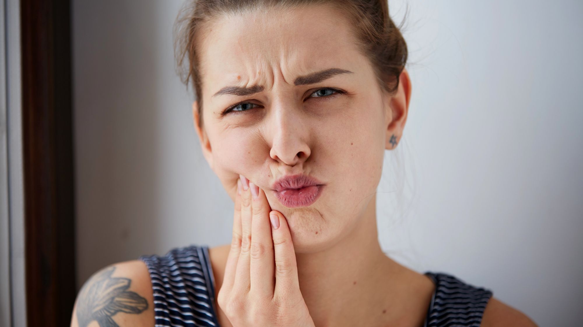 A woman is suffering from gum swelling under a tooth