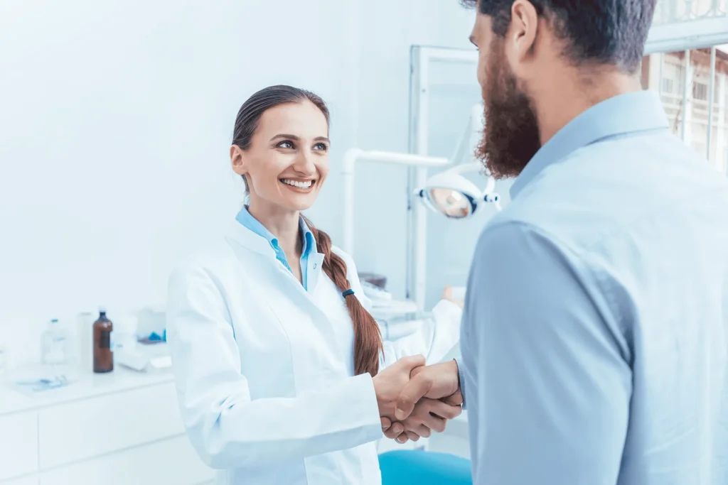 Dentist shaking hands with patient in a modern Tucson dental clinic showing trust and professional dental care service